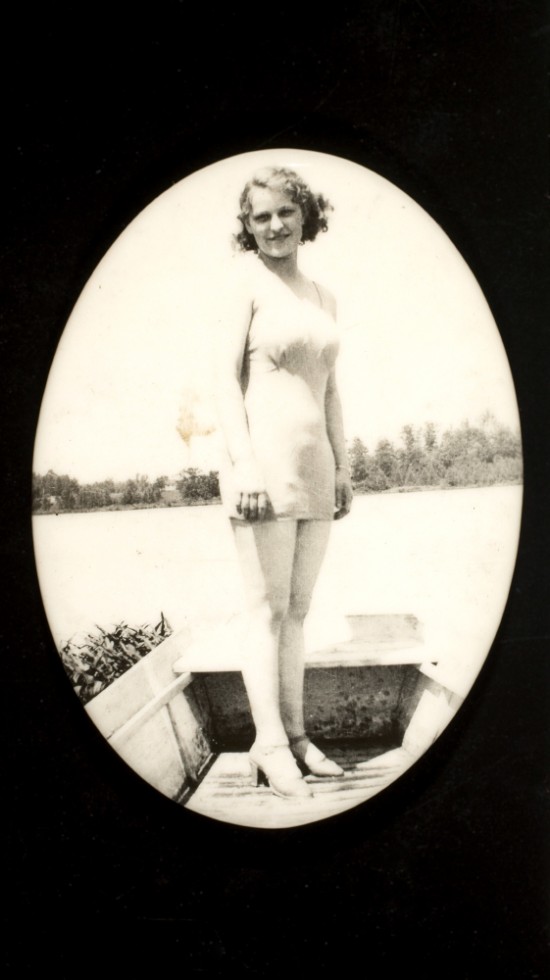 Woman in boat wearing bathing suit and high heels